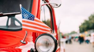 Paczki i przesyłki do USA – wszystko o wysyłce kurierskiej z Polski red-pickup-truck-with-small-american-flag-waving-2026-01-09-06-35-32-utc.